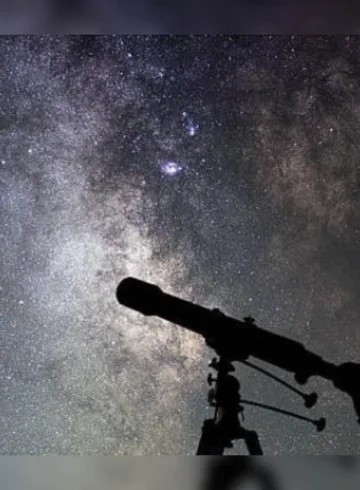 persona viendo por telescopio el cielo nocturno