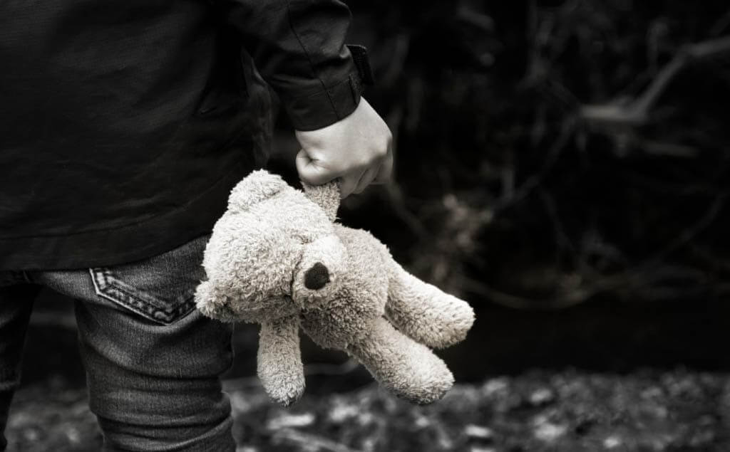 Hombre con un oso de peluche en la mano