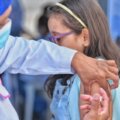 Personal de la salud vacunando a una niña en el brazo