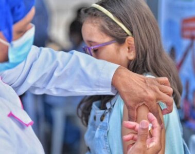 Personal de la salud vacunando a una niña en el brazo