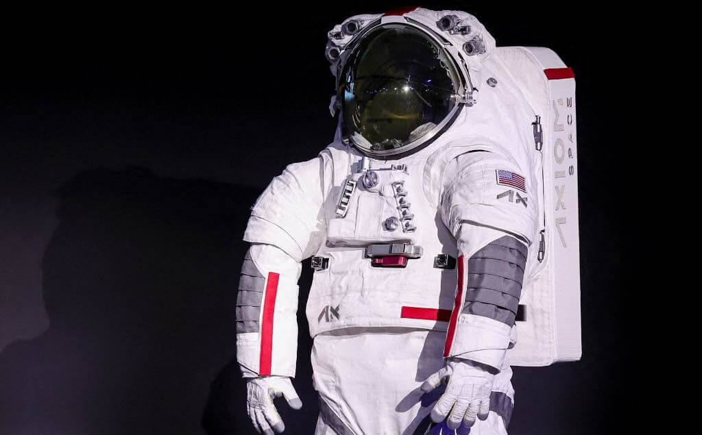 Prada colaborará con Axiom Space para diseñar los trajes espaciales de la misión Artemis III de la NASA en 2026, fusionando alta costura con tecnología avanzada. La moda hará su incursión en el espacio luego de que la casa de lujo italiana Prada anunciara en Milán que diseñará los trajes con los que los astronautas de la Nasa volverán al satélite en la misión Artemis III. Milán, donde se desarrolla el Congreso de Astronáutica.(H2) La empresa aeroespacial Axiom, contratista de la Nasa, confirmó que la firma italiana vestirá a los astronautas que en 2026 explorarán el polo sur del satélite. El traje contará con tecnología para que los astronautas puedan caminar 8 horas en el espacio. “Esta es una asociación innovadora”, dijo, por su parte, el vicepresidente ejecutivo de Axiom Space, Russel Ralston, “estamos combinando ingeniería, ciencia y arte”, agregó. “Hemos roto el molde. La asociación Axiom Space-Prada ha establecido un nuevo modelo fundamental para la colaboración entre industrias, ampliando aún más lo que es posible en el espacio comercial”, indicó el presidente de Axiom Space, Matt Ondler, durante la presentación el 16 de octubre. El traje se llama oficialmente AxEMU (de Axiom Extravehicular Mobility Unit) .(H2) La asociación Axiom Space-Prada en un comunicado señaló que el material blanco del traje, es capaz de reflejar el calor, ofreciendo protección contra “temperaturas extremas en el polo sur lunar” y soportará el frío extremo en “las regiones permanentemente en sombra durante al menos dos horas”. El traje es adaptable a diferentes tallas y fisonomías, pues se creó para que puedan usarlo tanto mujeres como hombres gracias a las técnicas de costura, lo que ayudó a “cerrar la brecha” entre funcionalidad y estilo, según el comunicado. Te puede interesar: Bad Bunny y Lionel Messi revelan innovadora colaboración con Adidas: “Esperamos crear un legado”