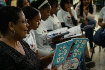 Grupo de niñas leyendo con una profesora