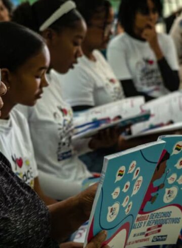 Grupo de niñas leyendo con una profesora