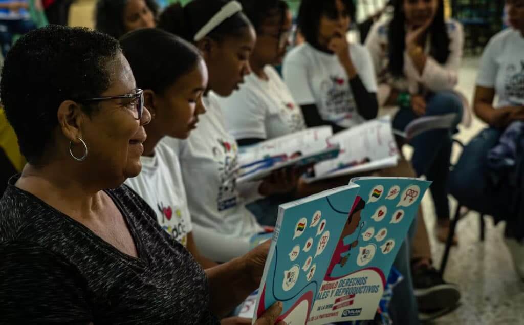 Grupo de niñas leyendo con una profesora