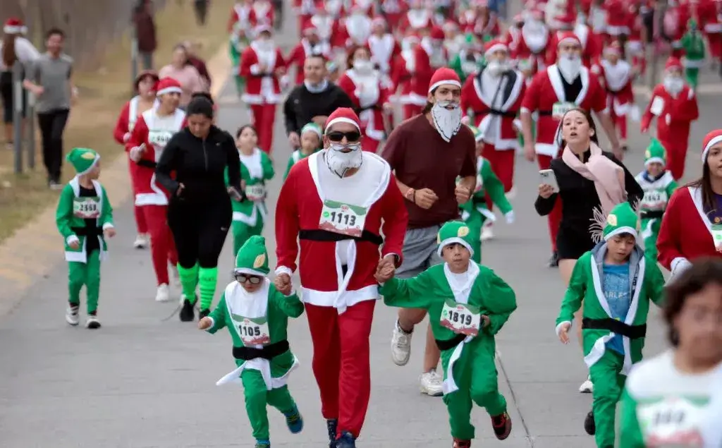 Personas corriendo en una carrera de Santa Claus