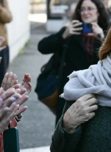 Giséle Pelicot, camiando en frente de mujeres que la aplauden