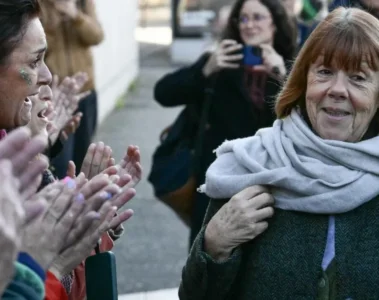 Giséle Pelicot, camiando en frente de mujeres que la aplauden