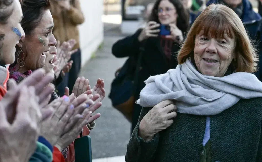 Giséle Pelicot, camiando en frente de mujeres que la aplauden