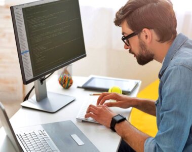 hombre sentado escribiendo en la compuradora