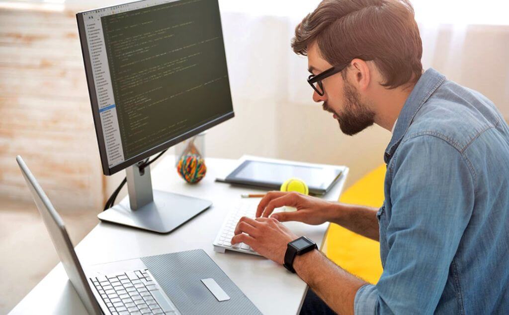 hombre sentado escribiendo en la compuradora