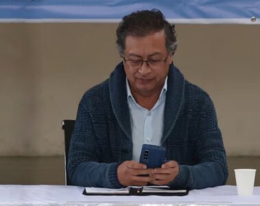 Gustavo Petro usando su celular en medio de un evento