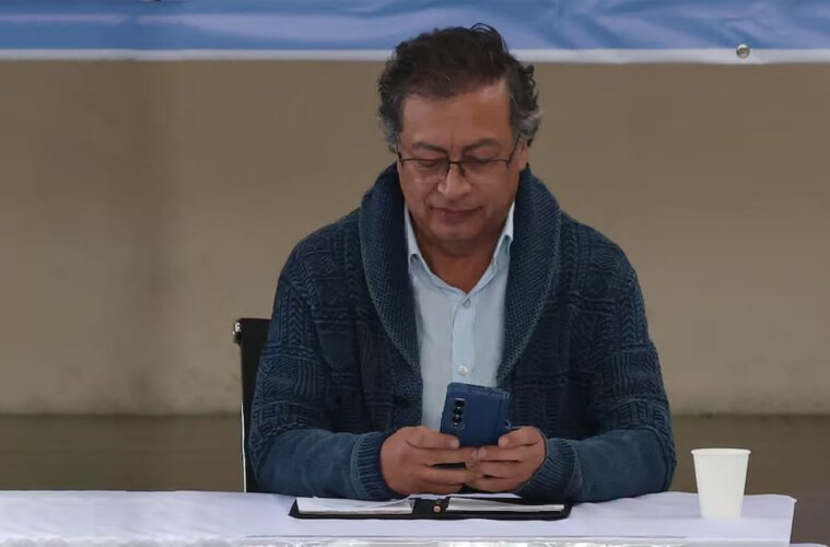 Gustavo Petro usando su celular en medio de un evento