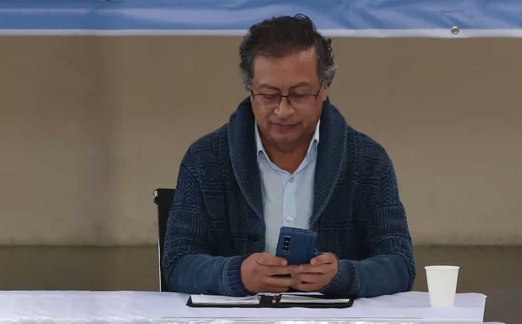 Gustavo Petro usando su celular en medio de un evento