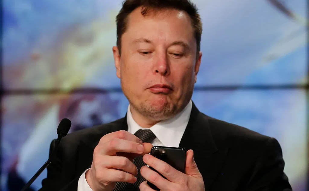 Elon Musk revisando su celular