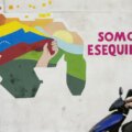 Un joven conduce una motocicleta frente a un mural con un mapa de Venezuela que incluye al territorio de Esequibo