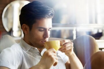 persona tomando cafe