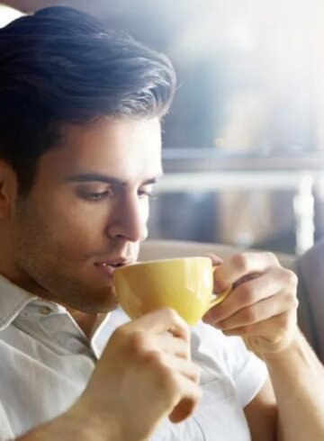 persona tomando cafe