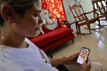 La cubana Heidy Sánchez observa una foto de su hija durante entrevista