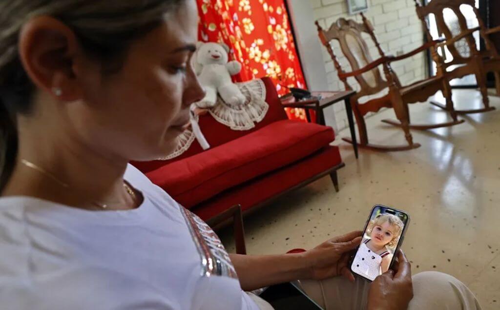 La cubana Heidy Sánchez observa una foto de su hija durante entrevista
