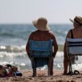 Personas tomando sol frente al mar