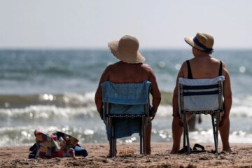 Personas tomando sol frente al mar