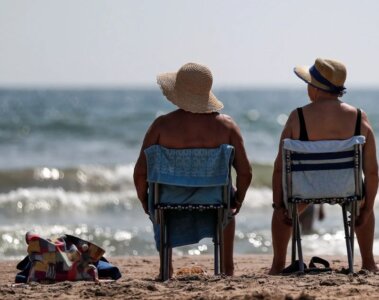 Personas tomando sol frente al mar
