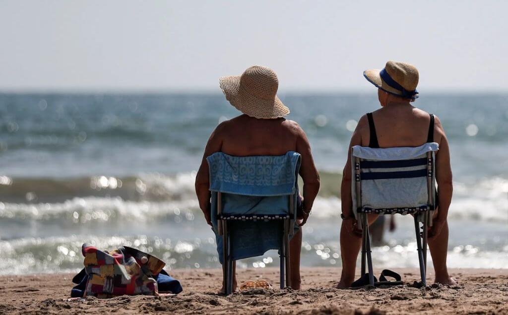 Personas tomando sol frente al mar