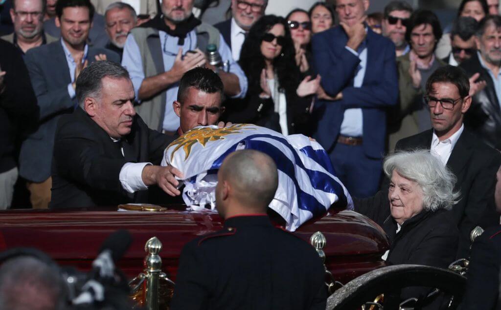 El presidente de Uruguay, Yamandú Orsi, extiende una bandera sobre el ataúd del exmandatario uruguayo José "Pepe" Mujica.