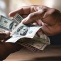 personas pasándose dolares